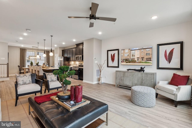 living room featuring recessed lighting, light wood-type flooring, and baseboards