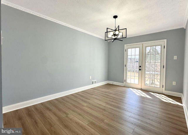 unfurnished dining area with french doors, wood finished floors, and ornamental molding