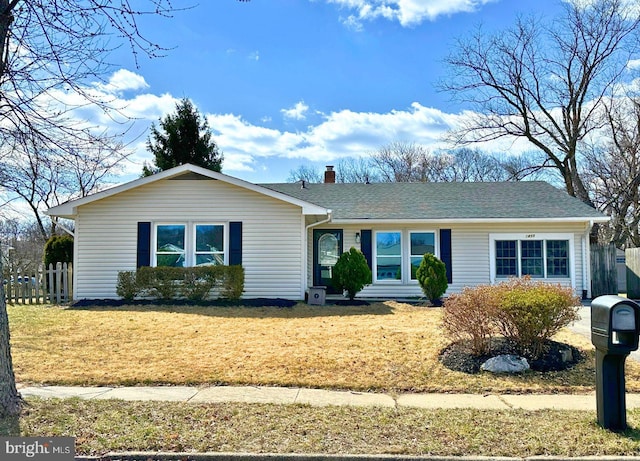 single story home with a chimney, a shingled roof, a front lawn, and fence