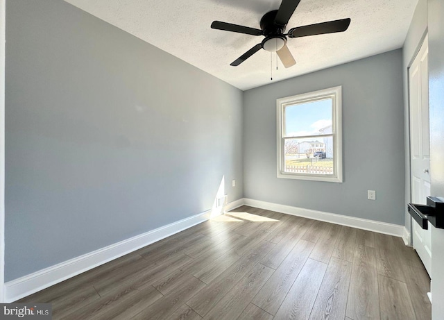 unfurnished bedroom with baseboards, a textured ceiling, ceiling fan, and dark wood-style flooring