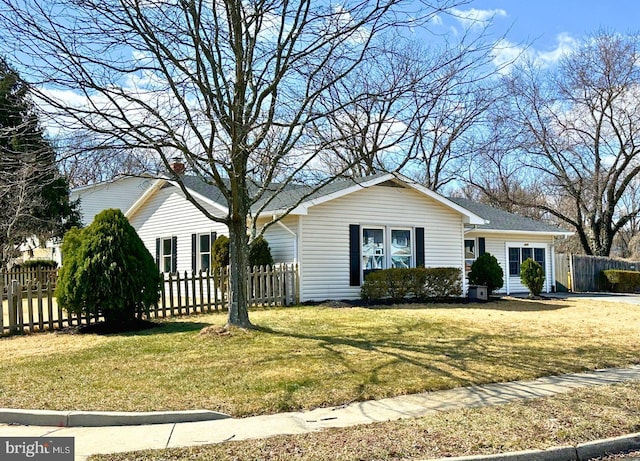 single story home featuring a front lawn and a fenced front yard