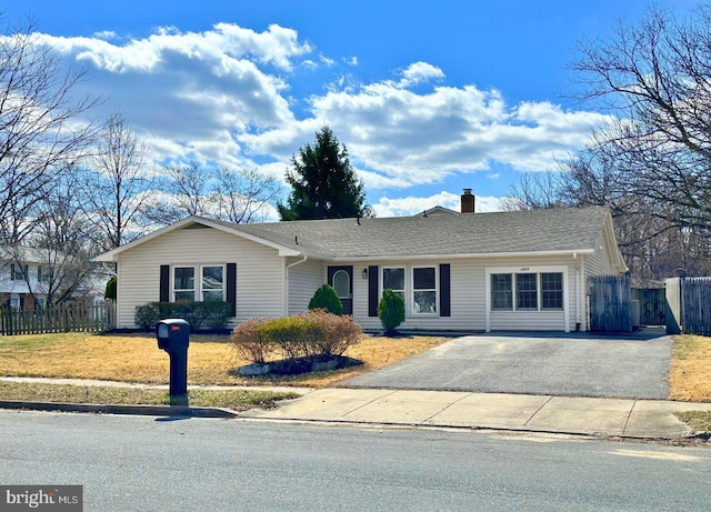 ranch-style house with a shingled roof, driveway, a chimney, and fence