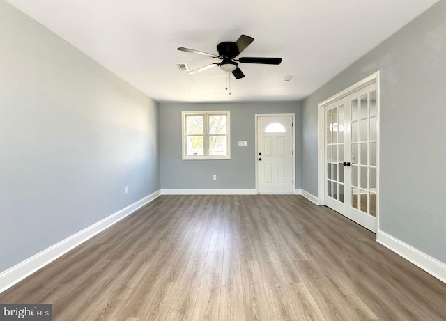 entrance foyer with visible vents, ceiling fan, baseboards, french doors, and wood finished floors