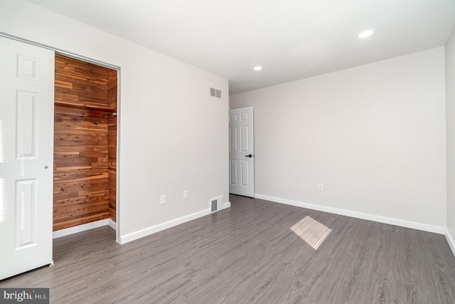 unfurnished bedroom featuring visible vents, baseboards, and wood finished floors