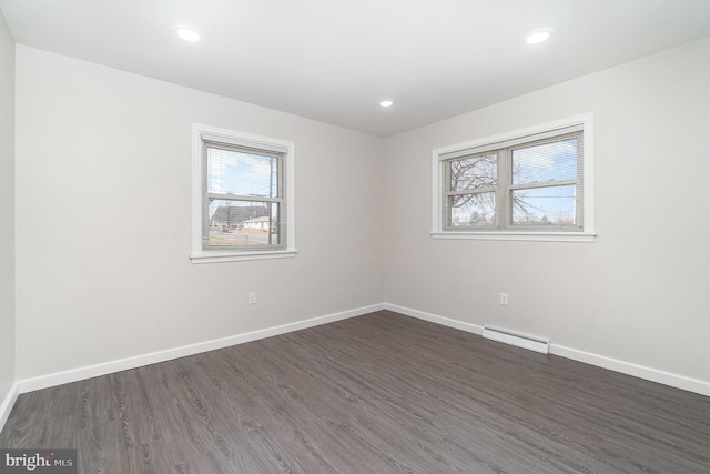 unfurnished room with dark wood-style flooring, recessed lighting, baseboards, and a wealth of natural light