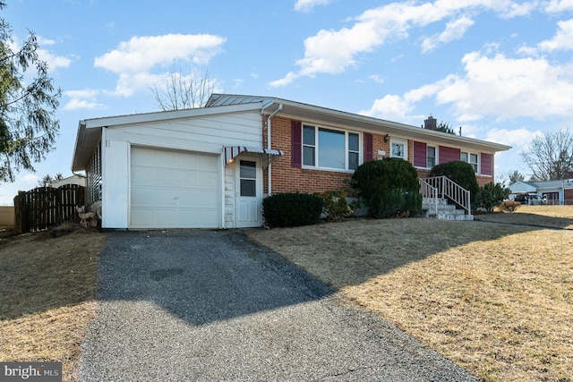 ranch-style home with aphalt driveway, an attached garage, brick siding, and fence