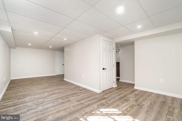 finished below grade area featuring baseboards and wood finished floors