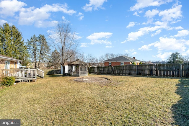 view of yard with a gazebo, a wooden deck, and fence