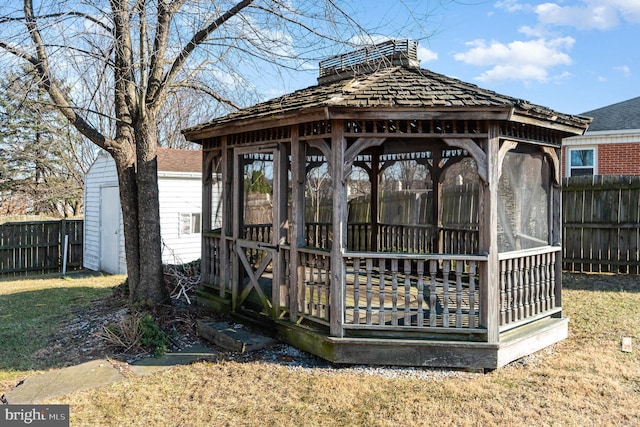 wooden terrace with a gazebo, an outdoor structure, and fence