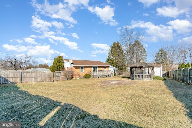 view of yard featuring a gazebo, a wooden deck, and a fenced backyard