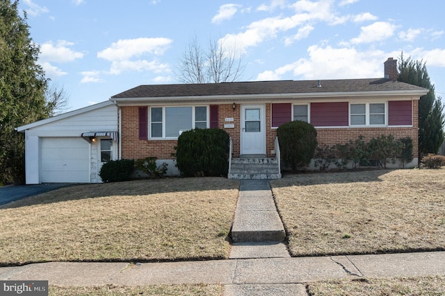 single story home featuring a front yard, brick siding, a chimney, and an attached garage