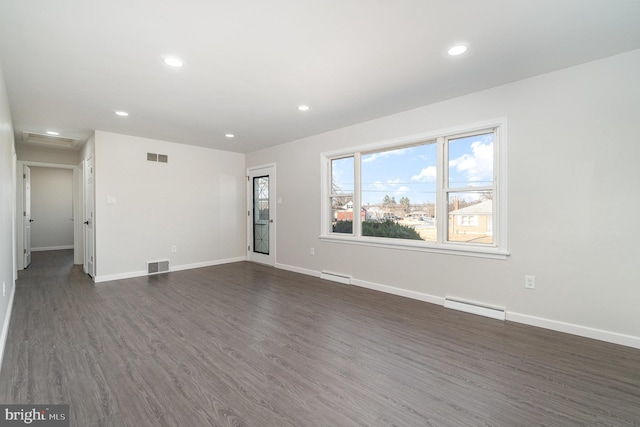 unfurnished living room with a baseboard heating unit, recessed lighting, dark wood finished floors, and visible vents