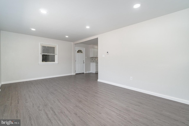 interior space featuring recessed lighting, baseboards, and wood finished floors