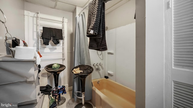 bathroom with tile patterned flooring, shower / bathtub combination with curtain, and a drop ceiling