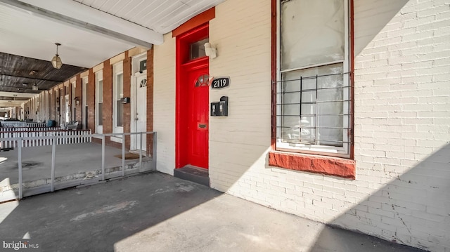 property entrance featuring brick siding and covered porch