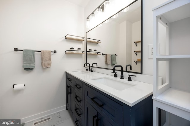 bathroom featuring visible vents, marble finish floor, baseboards, and a sink