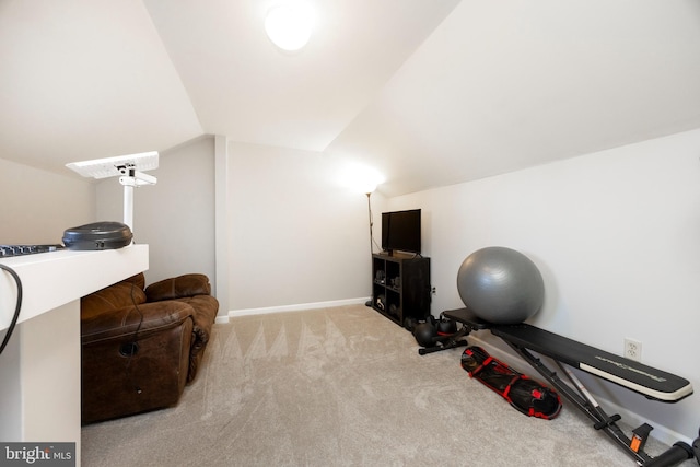 workout area featuring baseboards, lofted ceiling, and carpet floors