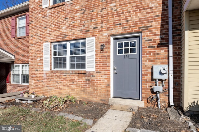 doorway to property with brick siding