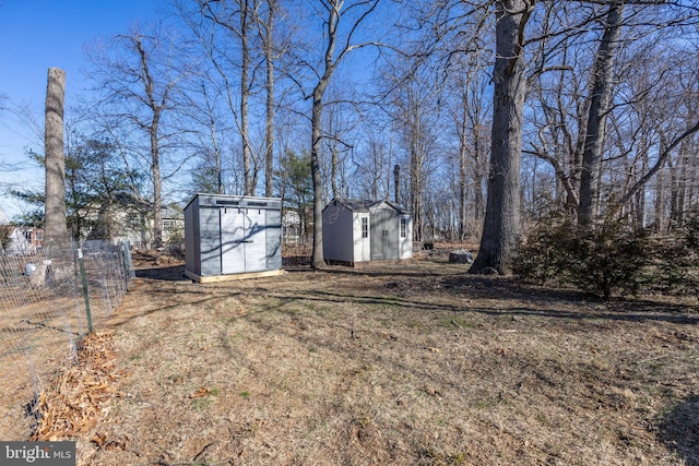 view of yard featuring an outdoor structure, fence, and a shed