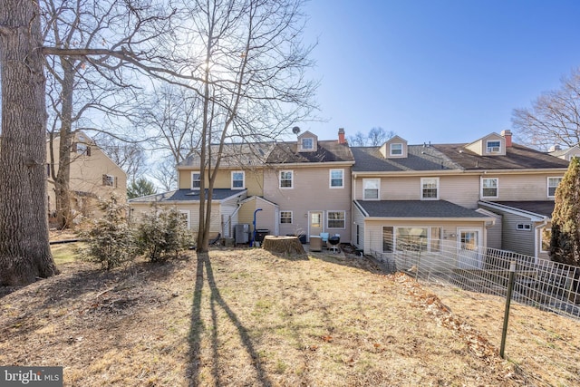 back of property featuring central AC and fence