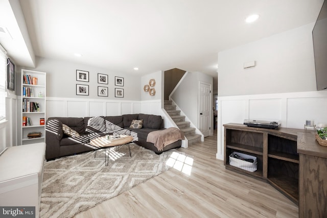 living area with a wainscoted wall, recessed lighting, stairs, and wood finished floors