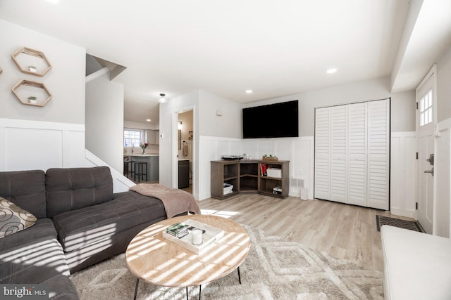 living area featuring recessed lighting, a wainscoted wall, and light wood finished floors