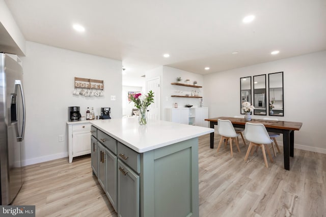 kitchen featuring a kitchen island, recessed lighting, stainless steel fridge with ice dispenser, light countertops, and light wood-type flooring