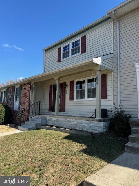 view of front of property featuring covered porch and a front lawn