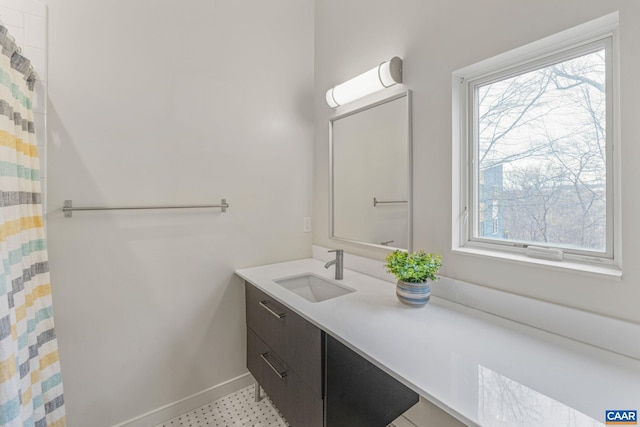 bathroom featuring curtained shower, vanity, and baseboards