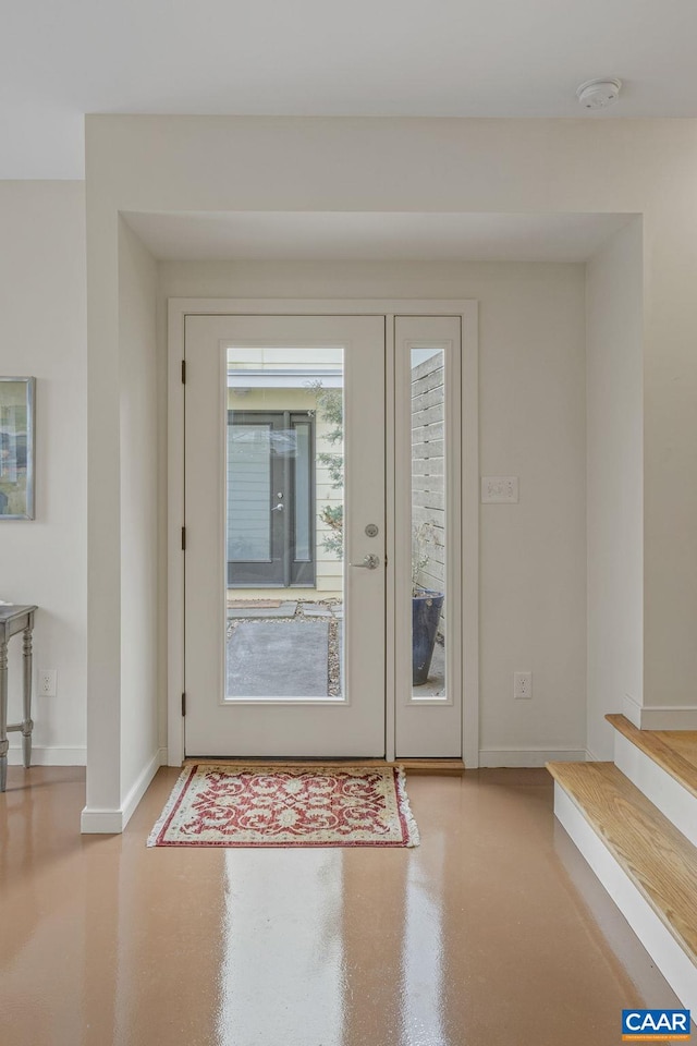 entrance foyer with baseboards and finished concrete flooring