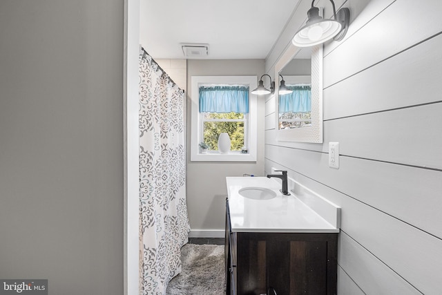 bathroom with visible vents, curtained shower, and vanity