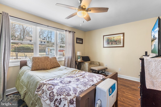 bedroom featuring baseboards, wood finished floors, and a ceiling fan