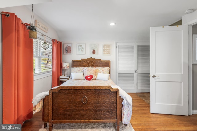 bedroom with recessed lighting, a closet, lofted ceiling, and light wood finished floors