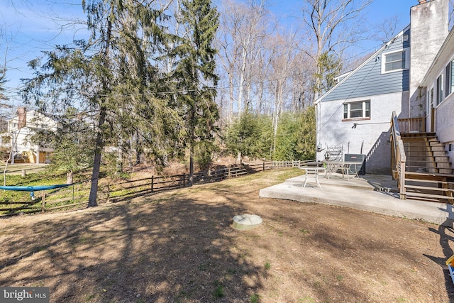 view of yard featuring stairs, a patio, and fence