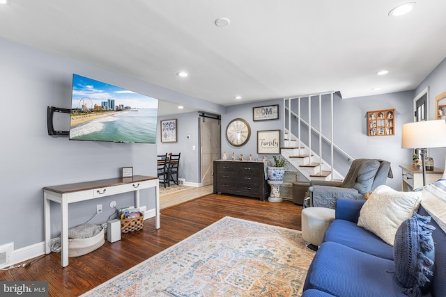 living area with stairs, a barn door, recessed lighting, and wood finished floors