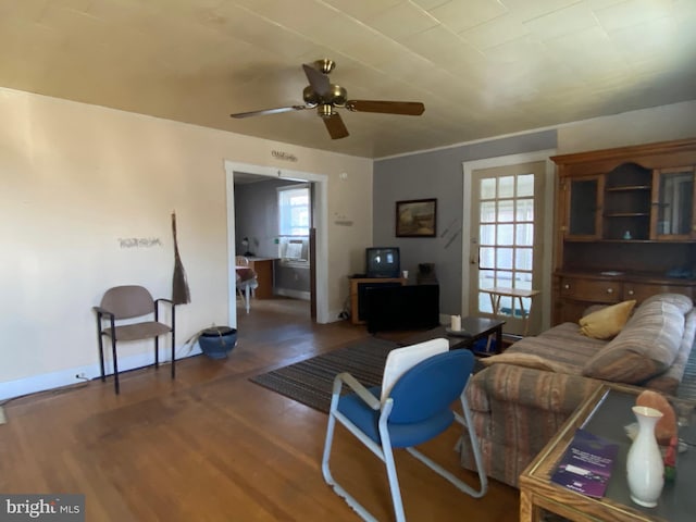 living room featuring a ceiling fan, plenty of natural light, wood finished floors, and baseboards