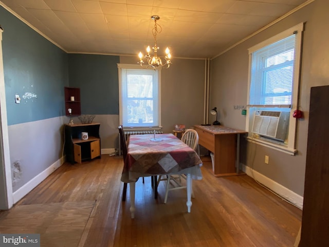 dining room featuring ornamental molding, wood finished floors, cooling unit, baseboards, and a chandelier