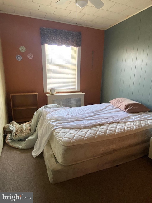 carpeted bedroom featuring radiator heating unit and ceiling fan