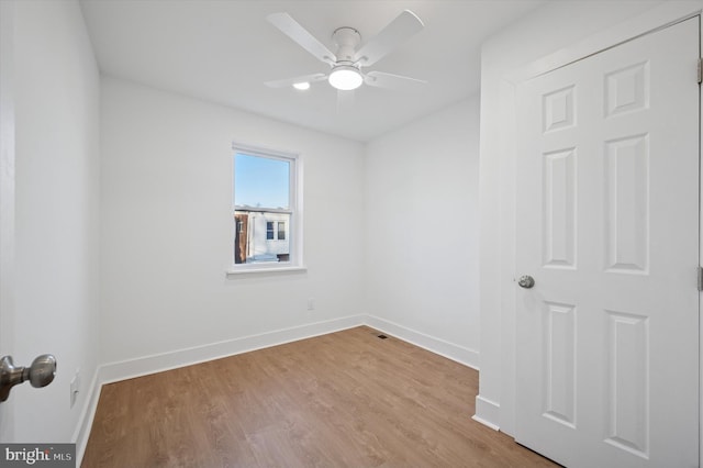 spare room featuring a ceiling fan, wood finished floors, and baseboards