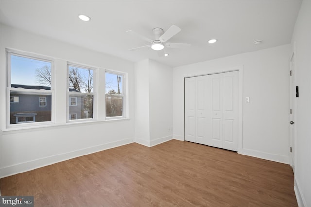 unfurnished bedroom featuring a ceiling fan, wood finished floors, recessed lighting, a closet, and baseboards