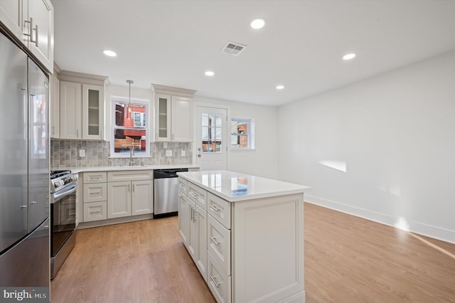 kitchen with visible vents, stainless steel appliances, light wood-type flooring, and light countertops