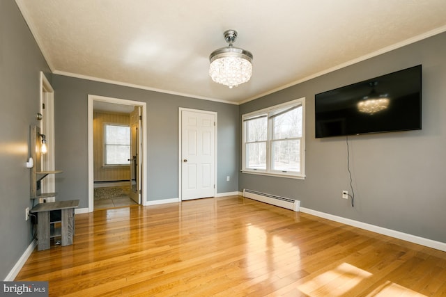 unfurnished bedroom with wood finished floors, baseboards, ornamental molding, baseboard heating, and a chandelier