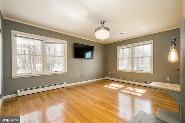 interior space featuring hardwood / wood-style floors, ornamental molding, plenty of natural light, and a baseboard radiator