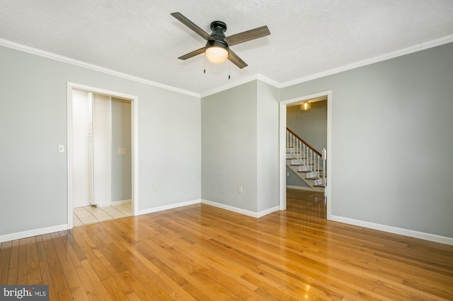 unfurnished room with crown molding, baseboards, and wood-type flooring