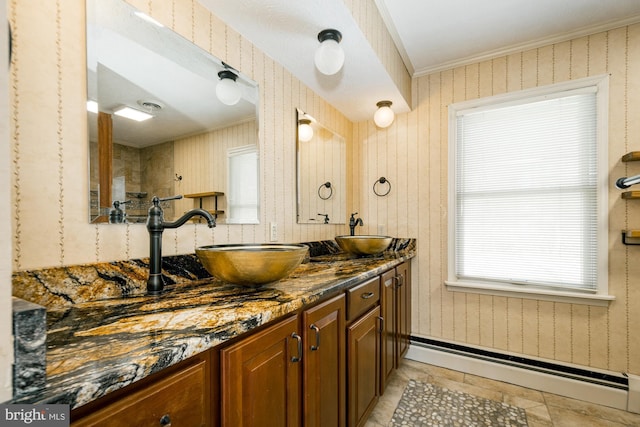 full bathroom featuring wallpapered walls, a baseboard heating unit, and a sink