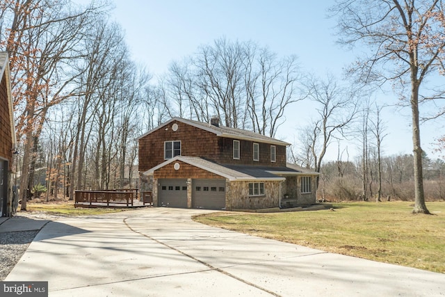 view of front of property with a chimney, an attached garage, concrete driveway, and a front yard