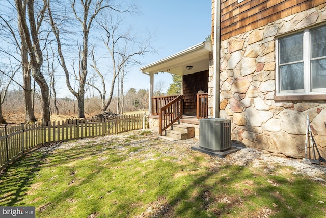 view of yard with central AC and fence