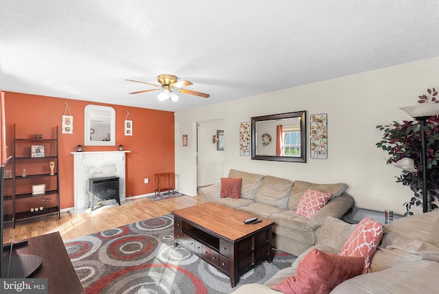 living area featuring a textured ceiling, a ceiling fan, and wood finished floors