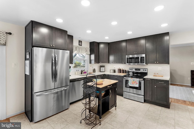 kitchen featuring recessed lighting, backsplash, appliances with stainless steel finishes, and light countertops