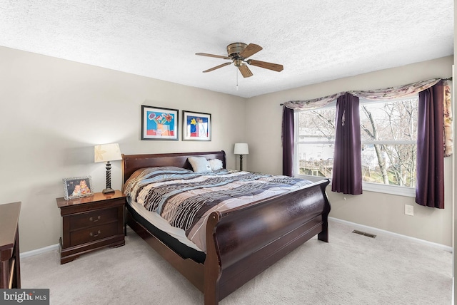 carpeted bedroom featuring visible vents, baseboards, a textured ceiling, and ceiling fan